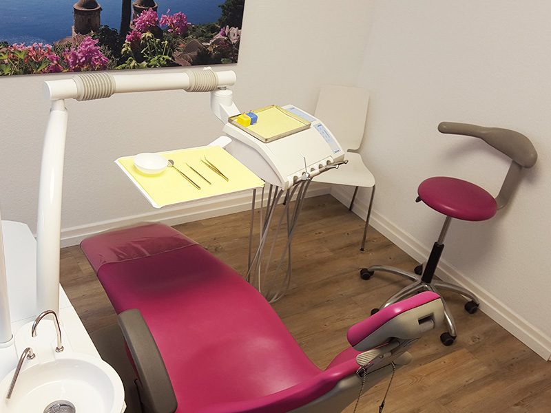 Behandlungszimmer mit pinkfarbenem Behandlungsstuhl